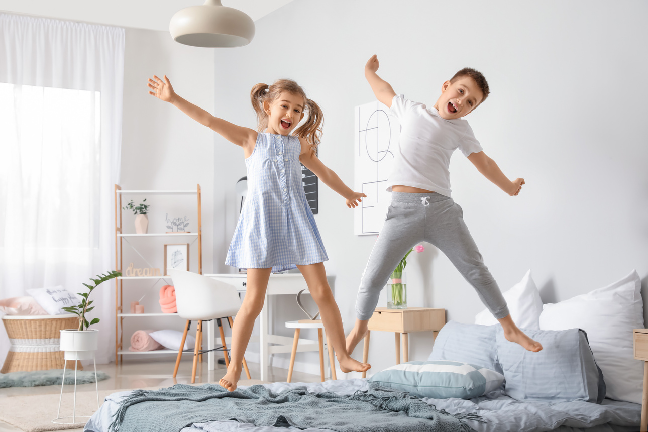 Happy Children Having Fun in Bedroom at Home